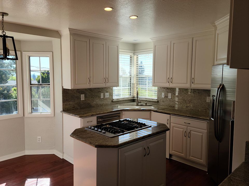 Kitchen features granite counter-top with stainless steel cooktop, refrigderator, dish washer, food disposer, double ovens and microwave. On the left is a breakfast nook for informal meals.