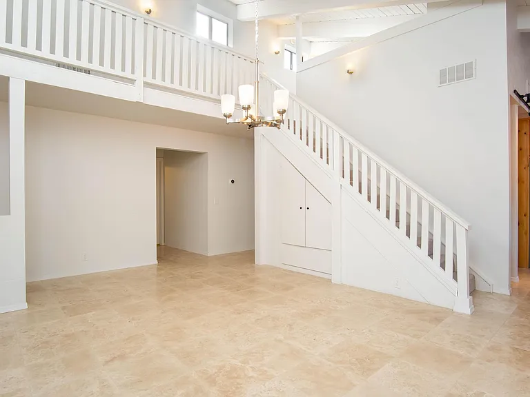 Hallway leading to garage and stairs leading to loft space