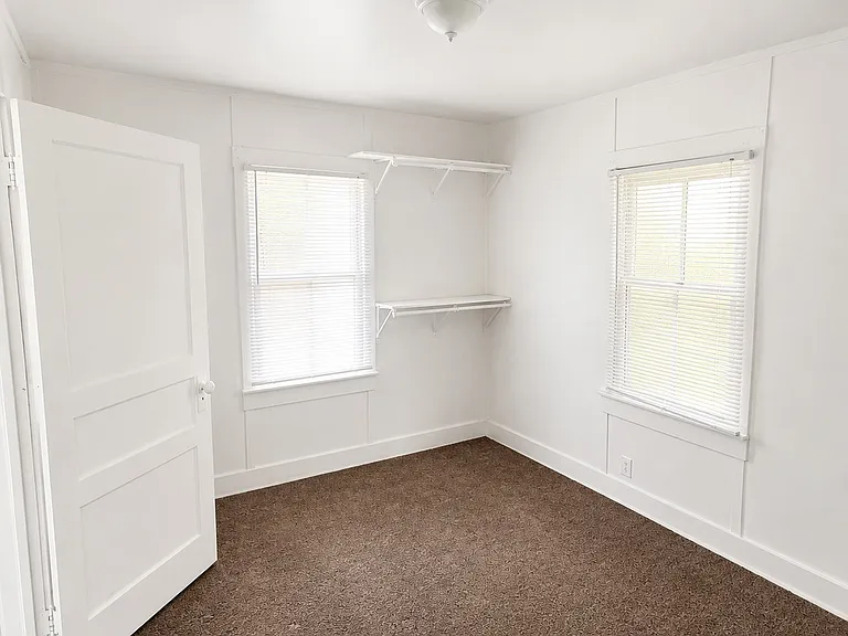 Comfortable Second Bedroom with natural light and convenient closet shelving.