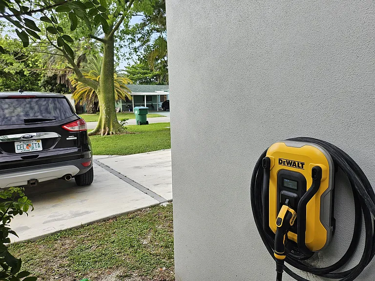 Electric car EV charging station next to driveway