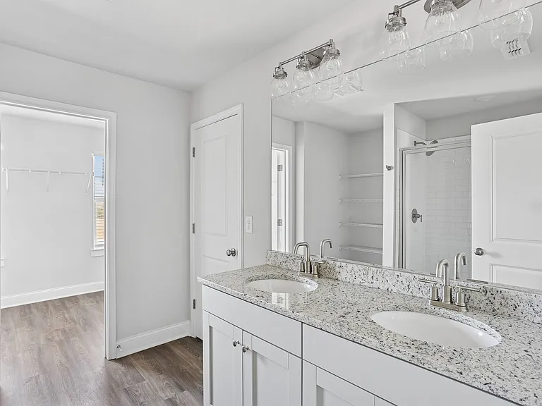 Primary bathroom with double vanity, and walk-in shower.