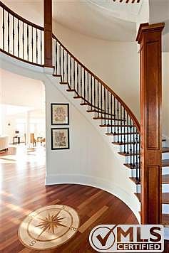 Step into the front entry foyer, showing the hardwood flooring and special staircase that rises thre