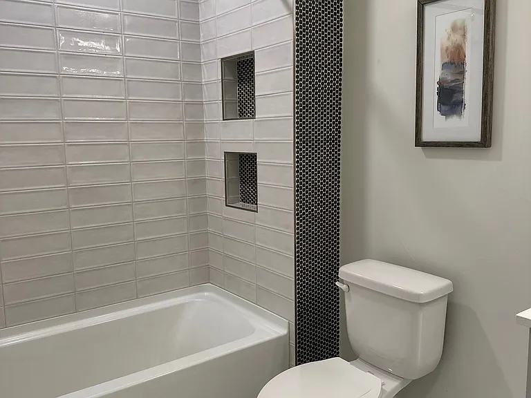 Modern bathroom with tub/shower and floating cabinet sink