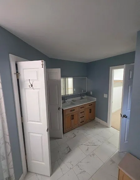Newly renovated Primary Bathroom inside the primary Bedroom with brand new tiles, wall paint, vanity counter, mirror, and lights