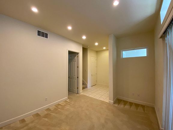 Family Room open floor with entrance to 1st floor bedroom (on left). Sliding Glass Door to outside front porch patio