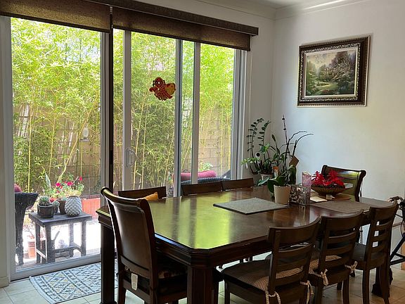 Spacious dining room off kitchen with slider door to patio with lush bamboo plants which add extra privacy