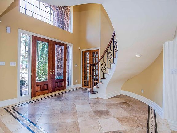 Sweeping staircase and iron detailing welcomes guests and offers a formal hello.