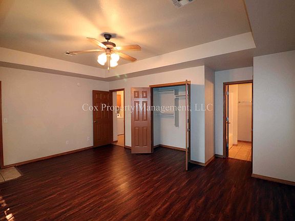 Master bedroom with backyard access, private bathroom, ceiling fan, and large closet