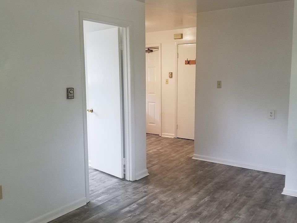 Living room view of bedroom door and kitchen around the corner to the left