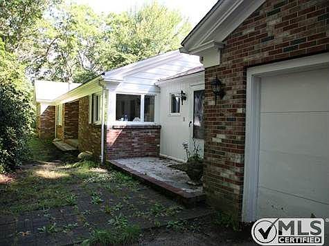 Front side of house is brick with stone wall and vegetation to insure privacy.