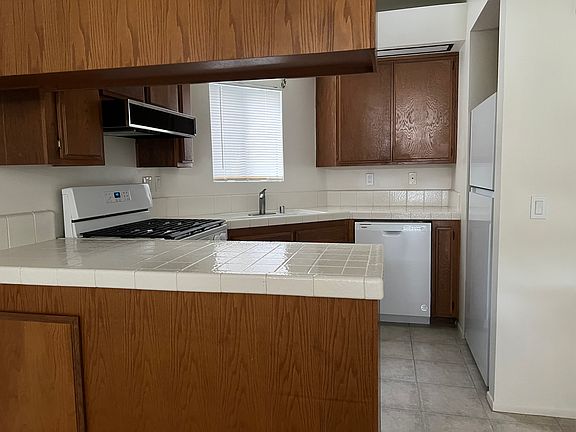 New Refrigerator 
White Tile Counters/Custom Cabinets