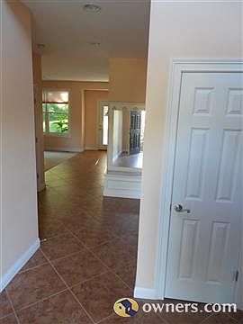 Front door with open foyer and chandelier