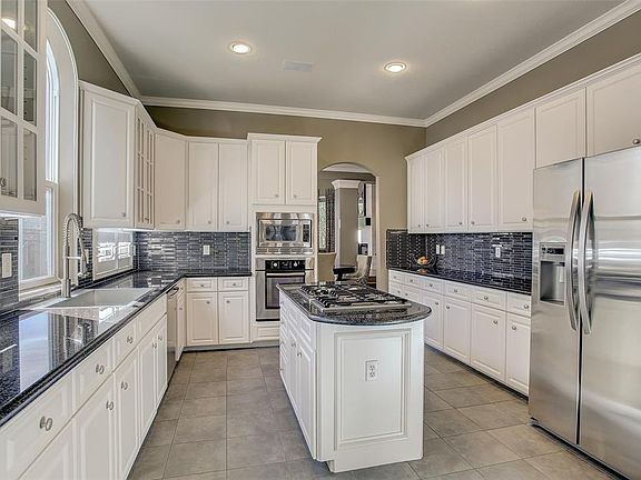 This kitchen is a chefâs dream â with granite counters, decorative glass tile backsplash, and tons of storage!