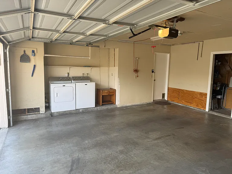 Two-car garage with washer/dryer and additional storage area. New wifi-enabled garage door opener.