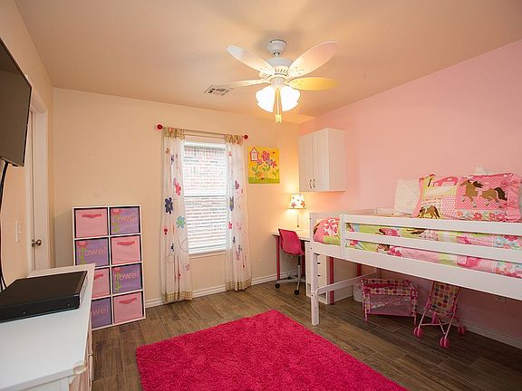 Charming 2nd Bedroom with wood-like tile floors, ceiling fan and walk-in closet.