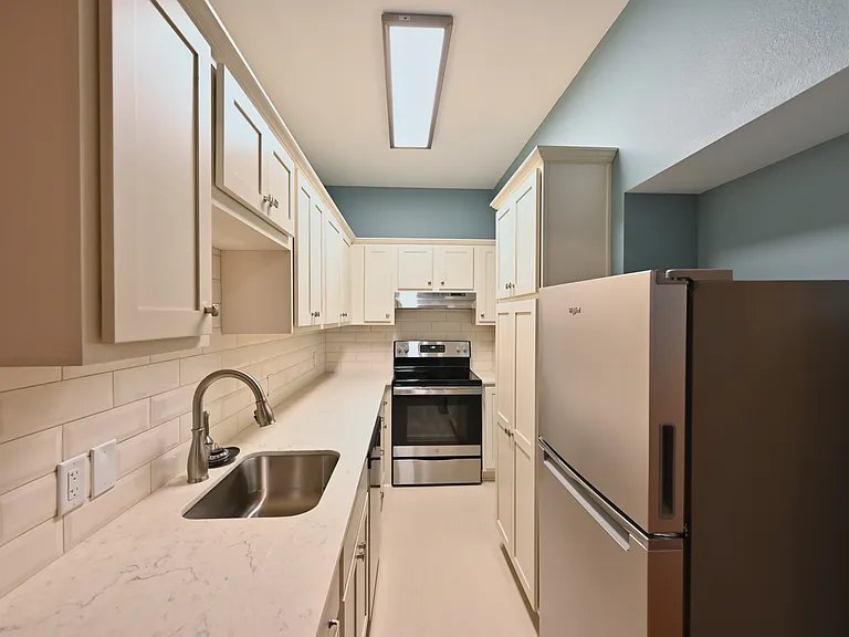 Galley kitchen with dishwasher, stove, frig, pantry and lots of storage cabinets and drawers