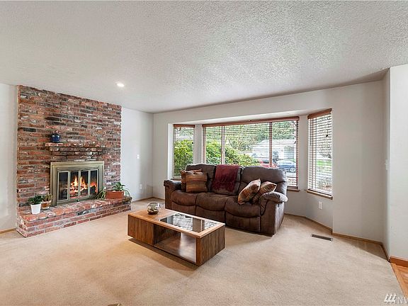 Formal living room with wood burning fireplace.  Bay window for 