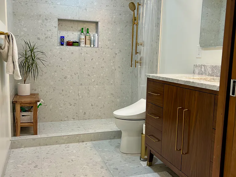 Primary bedroom's en-suite bathroom featuring a Kohler rainfall shower head, Toto toilet with washlet bidet, heated floors, and a marble topped vanity.