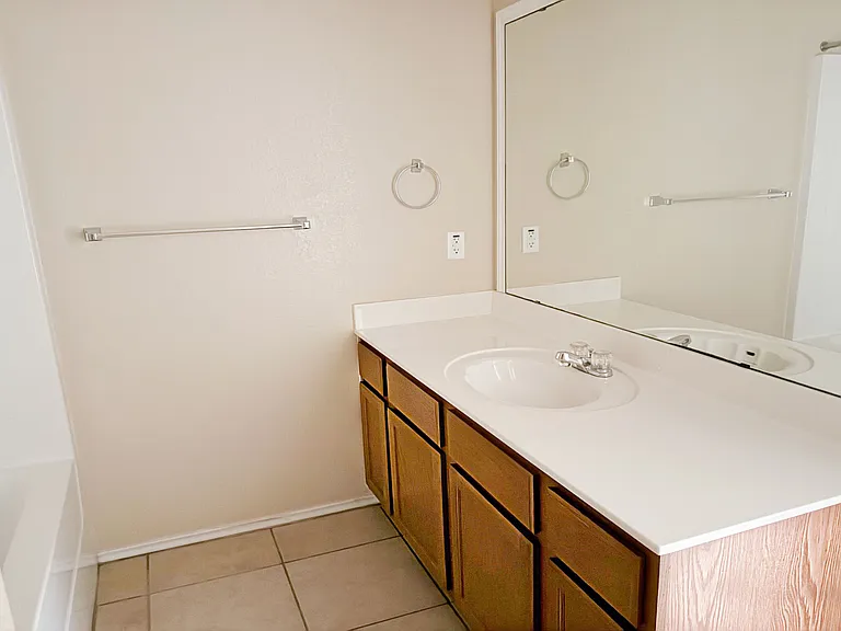 The hall bathroom sink side with cabinets for the 3 bedrooms.