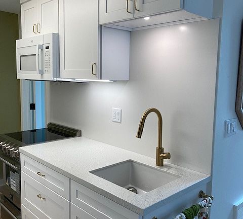 Kitchen range, microwave, sink with garbage disposal and under-cabinet lighting throughout