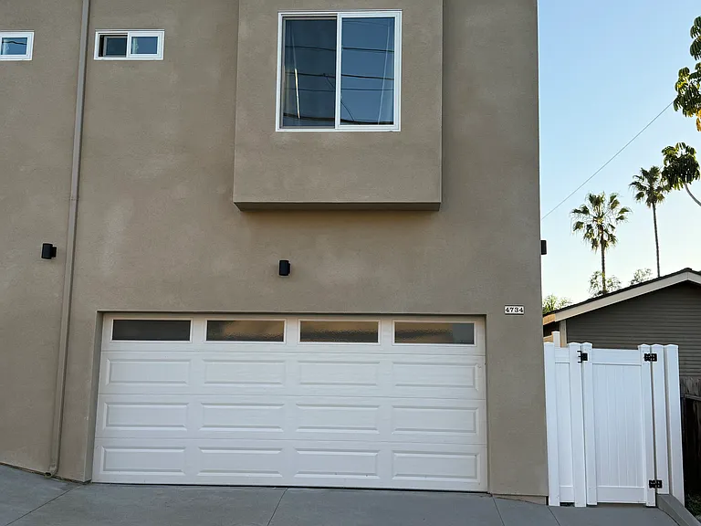 Rear of property off alley with 2 car garage and entrance into townhouse