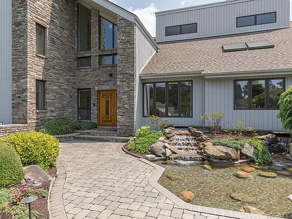 Gorgeous paved walk-way bordered by professional landscaping and waterfall lead you to this most distinctive property!