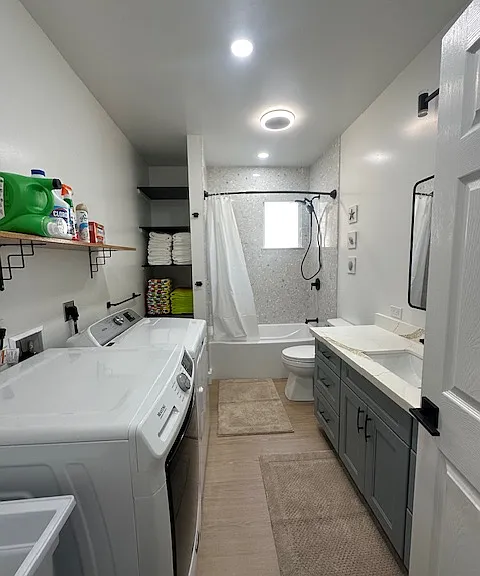 Guest Bathroom with clothes washer, dryer & utility sink.