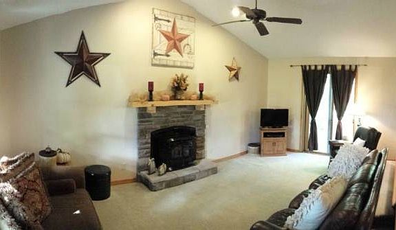 Living room with vaulted ceiling and fireplace with newer wood/corn insert