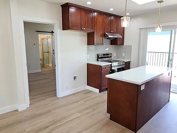 Island/cooking area and entry way to master bedroom. New refrigerator will be provided prior to move-in.