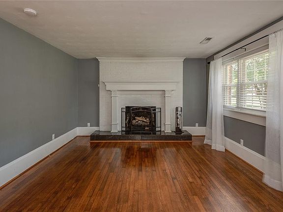 Living room with lovely hardwood floors, 8" baseboards, & gas fireplace