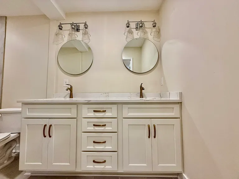 Newly renovated bathroom with double vanity and quartz countertops off of Bedroom #1