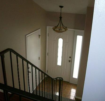 Inviting entry hall from the upstairs walkway with rod iron railings and updated light fixture