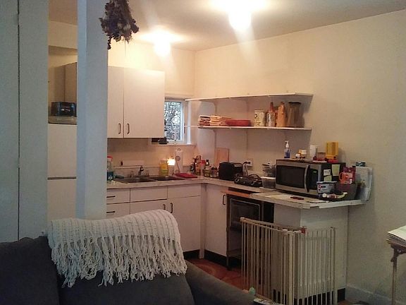 Kitchen open to living / dining area. About to be renovated with new cabinets, counters, sink and full size stove.