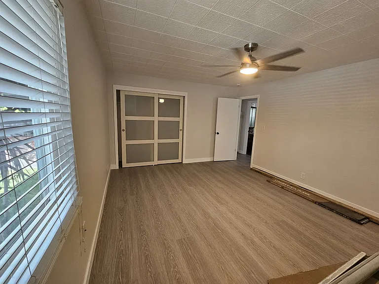 Large second bedroom with new ceiling fan and vinyl plank floors.
