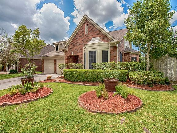 Lush landscaping with stone accents line the front of the home.