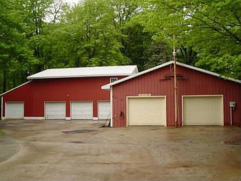 The back polebarn pictured is two story's and is 30x40. The upstairs has many uses, and it has four garage doors! The front polebarn pictured features an auto lift, a wood stove that is pictured below and air conditioning. 