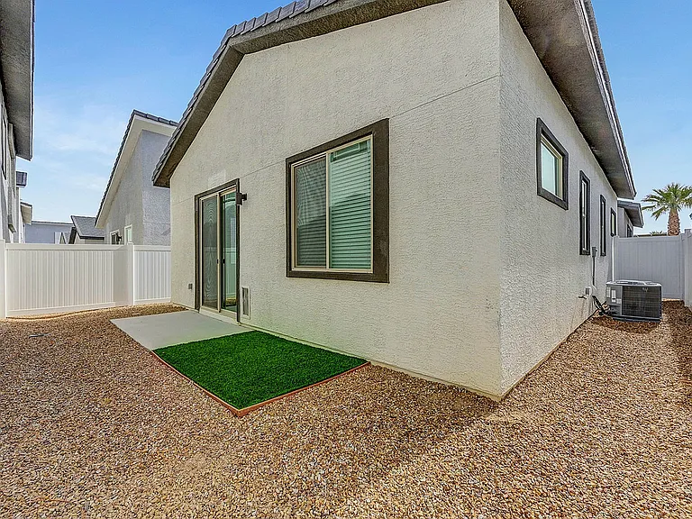 Experience the serenity of this charming side yard, featuring sleek architecture and a touch of greenery.