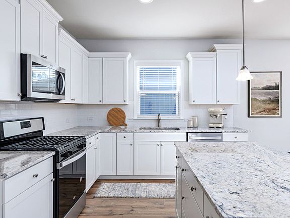 Timeless white kitchen with granite countertops and an oversized island.