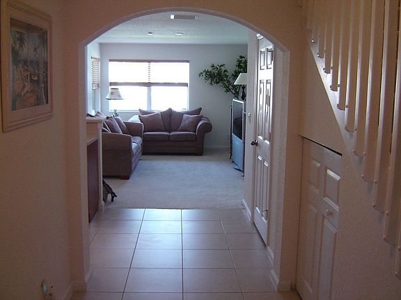Hallway with stairs on right, garage on left and living room straight ahead