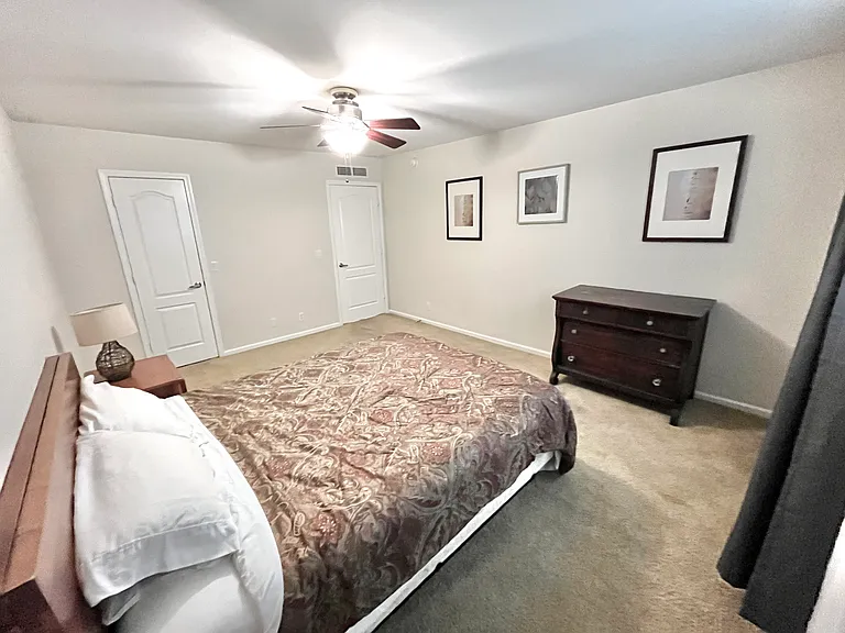 Bedroom with queen bed (sheets and comforter included), dresser, night stand, a night lamp, pictures and blackout drapes
