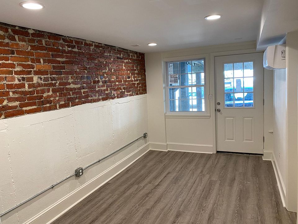 Bedroom with window and door on alley. Parking spot directly outside.