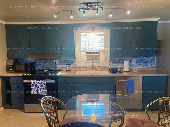 Kitchen features stainless stove, dishwasher, and refrigerator.