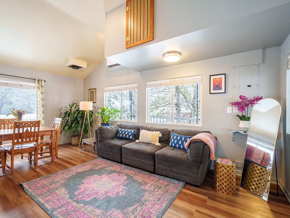 Open living room with high-vaulted ceiling, new hardwood floor, and natural light.