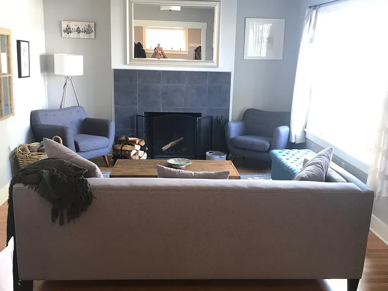 Living room with wood burning fireplace (fire grate, tools, wood storage rack and fireplace guard will remain in house)