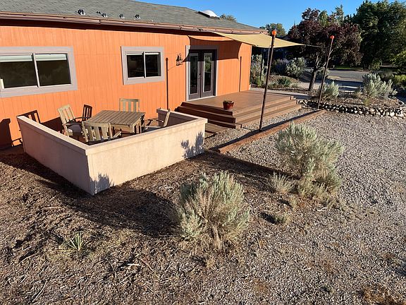 Patio with front entry and deck in background