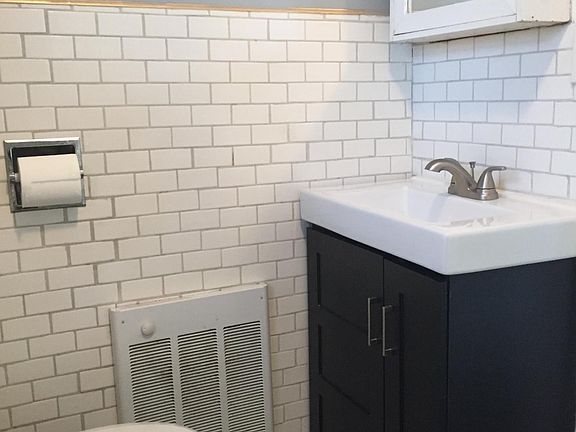 The one bathroom has been updated with subway tile, new vanity and sink, and flooring