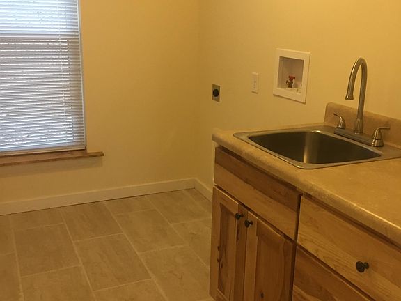The laundry room has a wash tub, washer/ dryer hookup and a closet