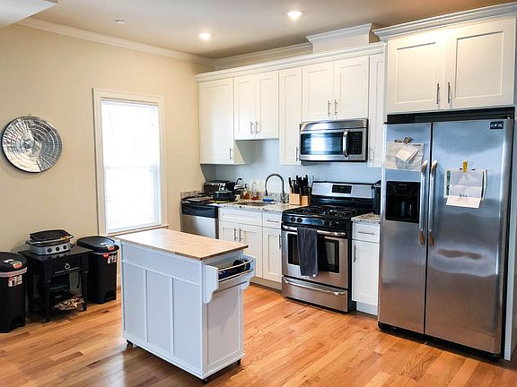 Renovated kitchen with granite counters, stainless steel appliances (including dishwasher, gas stove, & microwave)
