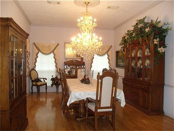 Formal dining room with 10' ceilings, crown molding, and chandelier.