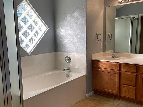 Primary Bathroom with deep tub, dual sinks, and separate shower.